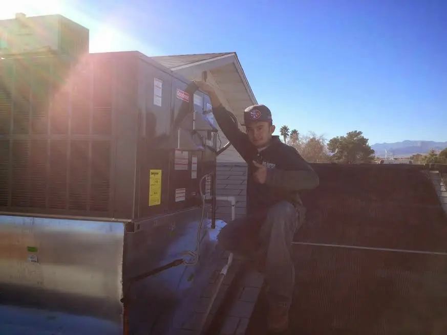 HVAC technician performing AC Tune-Up on a rooftop unit in Glencoe